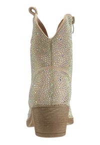 Botín beige con un bajo tacón de madera, adornado con brillantes de colores vibrantes, con punta redonda y una tira en la parte trasera para facilitar su uso.