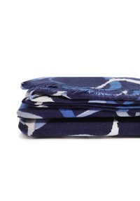 Tessuto piegato di un blu scuro con un motivo floreale in diverse tonalità di blu, caratterizzato da bordi frangiati e una superficie liscia.