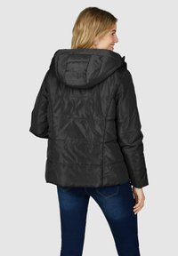 Schwarze Daunenjacke mit Kapuze, ausgestattet mit einem gesteppten Design, langen Ärmeln und einer leicht lockeren Passform. Der Stoff wirkt glänzend und hat eine glatte Textur.