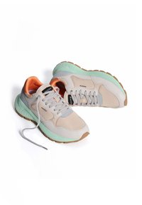 Zapatillas deportivas beige y verde menta con acentos grises y un interior naranja, que presentan una suela texturizada y una marca en la lengüeta.