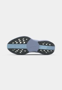 Nike shoes with a purple and black sole. Features a textured surface with white accents and a prominent logo on the midsole.