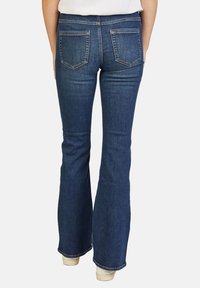 Uitgebreide spijkerbroek in donkerblauw met twee achterzakken, gestikte details en een lichte rekbare stof voor comfort.