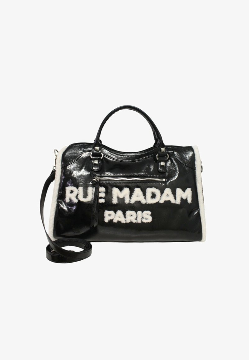 Musta lakattu nahkalaukku, jossa on valkoiset tekoturkiskoristeet. Laukussa on rohkeasti valkoisella kirjoitettu teksti "RUE MADAM PARIS" ja säädettävä olkahihna.