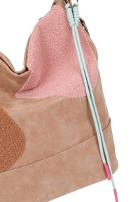 Borsa a mano in suede rosa chiaro e beige con toppe in tessuto testurizzato e due cordini azzurri chiari con punte rosa.