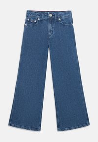 Jean large en denim bleu foncé avec une finition légèrement texturée, dotée de poches avant, d'une fermeture à bouton et de détails de couture contrastants.