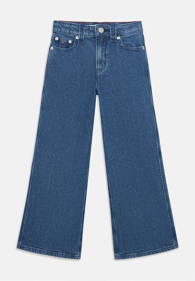 Jean large en denim bleu foncé avec une finition légèrement texturée, dotée de poches avant, d'une fermeture à bouton et de détails de couture contrastants.