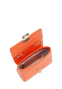 Pochette en cuir orange avec une finition texturée, des ferrures dorées et une fermeture à clapet ; dotée d'un intérieur en tissu argenté. Vue de dessus ouverte.