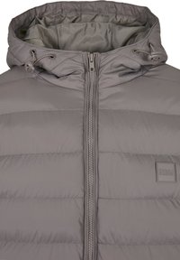 Grå vadderad jacka med huva, framdragkedja, justerbara dragsko och en liten "Urban Classics" loggopatch på bröstet.