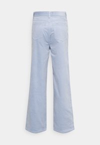 Pantalon large en velours côtelé bleu clair vu de dos avec deux poches arrière et passants pour ceinture à la taille.