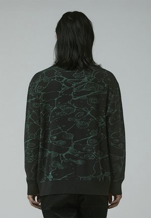 Maglione nero a maniche lunghe con un motivo astratto verde testurizzato. Polsini e orlo a coste, con una vestibilità rilassata.
