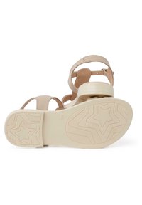 Beige sandaalit korkokengät, joissa on leveät remmit ja teksturoitu kumipohja, jossa on tähtikuviot. Korko on keskipituinen ja sillä on sileä pinta.