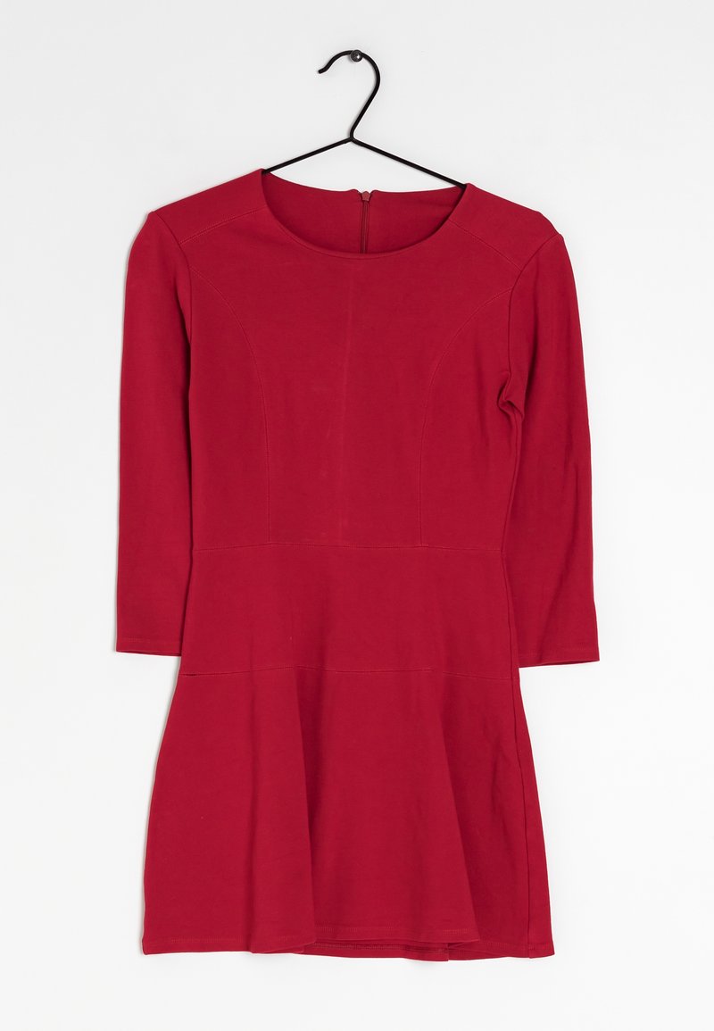 Robe rouge mi-longue avec manches longues sur un cintre noir sur fond blanc.