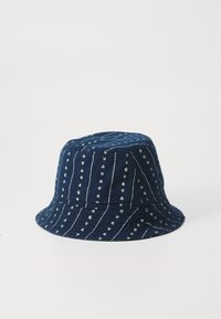 Pălărie de marină, fabricată din material textil, cu dungi verticale albe și modele mici de inimioare. Textură moale, bor larg și flexibil.