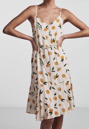 Vestido ligero color crema con estampado de rodajas de naranja y hojas, tirantes finos ajustables, escote en V y cintura con cordón. Dobladillo acampanado.
