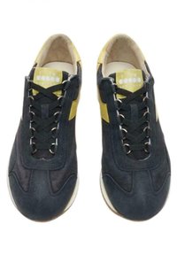 Scarpe sportive nere e gialle realizzate in suede e mesh, con punta arrotondata, lacci piatti e occhielli in metallo. Suole in gomma bianca con leggera texture.