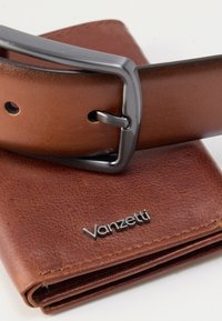 Braune Lederbrieftasche mit strukturierter Oberfläche und klappbarem Design, kombiniert mit einer dunkelgrauen Metallschnalle an einem passenden braunen Gürtel.