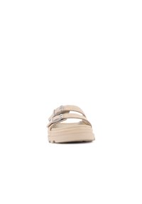 Sandali beige con due cinturini regolabili, fibbie argento, suola piatta in gomma e superficie testurizzata. Il design enfatizza il comfort e la semplicità.