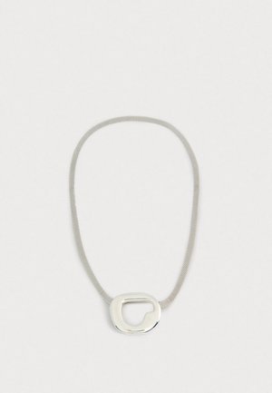 Hõbedane sõrmus, millel on ovaalne ripats, millel on lõikekujundus, ühendades siledad ja tekstuuritud pinnad. Elegantne ja kaasaegne välimus.