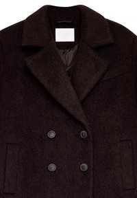 Rudas vilnos mišinys dvigubos sagos paltas su plačiu apykakle, didelėmis juodomis sagomis ir minkšta tekstūrine danga. Su šoninėmis kišenėmis.