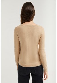 Beige, soft-knit sweater with long sleeves and scoop neck. Features a fitted hem and subtle texture. Viewed from the back.