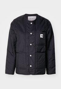 Schwarze, gesteppten Jacke mit rundem Ausschnitt, Druckknöpfen, einer aufgesetzten Tasche und sichtbaren Nähten. Verfügt über ein Logo auf der Tasche. Glatte Textur.