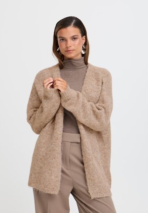 Cardigan lungo aperto in beige chiaro, realizzato in materiale morbido e strutturato. Caratterizzato da spalle scese e orli sfilacciati per un look informale.