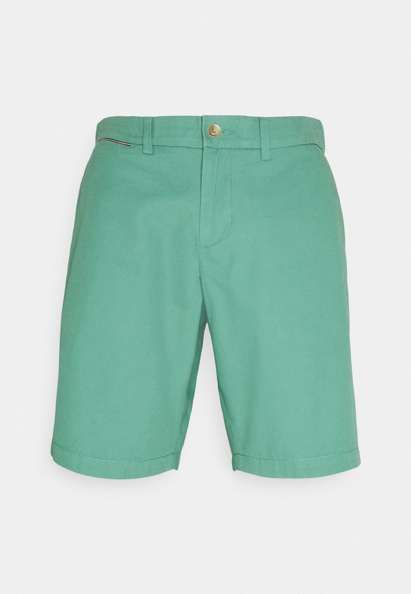Shorts verts longueur genou avec passants pour ceinture, fermeture à bouton et zip à l'avant, et un petit détail drapeau sur le côté droit près de la taille.