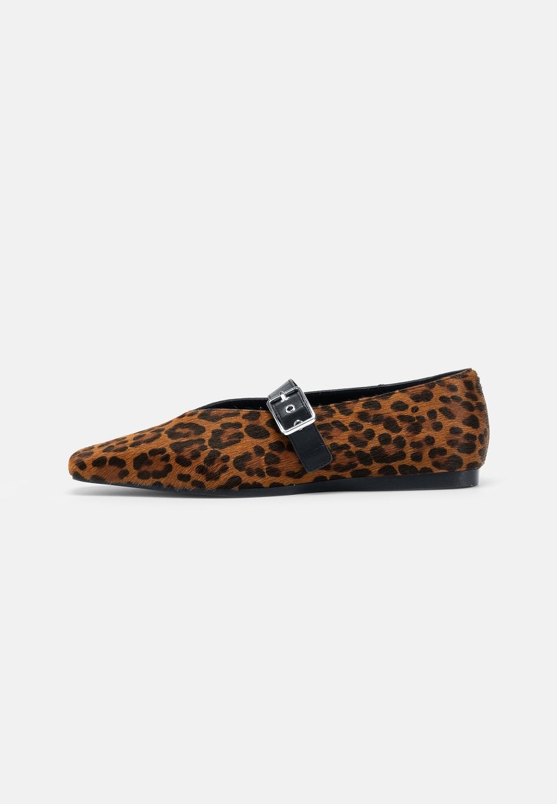 Chaussure plate avec imprimé léopard, bout pointu et bride noire avec boucle argentée sur fond blanc.