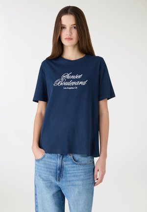 Granatowy bawełniany T-shirt z haftowanym białym napisem „Sunset Boulevard, Los Angeles, CA” w stylu kursywy. Luźny krój z krótkimi rękawami.