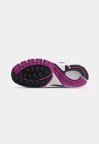 Suola della scarpa da corsa con un motivo in gomma nero e viola, intersuola bianca testurizzata e design del tallone curvo per trazione e supporto.