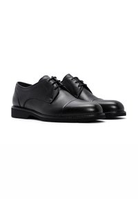 Chaussures habillées en cuir noir avec un bout arrondi, des lacets plats et une semelle robuste, avec un minimalisme dans les détails pour une apparence soignée.