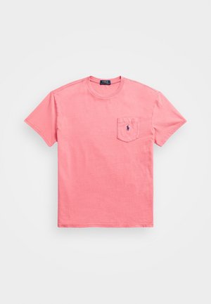 Różowa koszulka z krótkim rękawem i okrągłym dekoltem, z kieszonką na piersi z przodu i małym granatowym logo kucyka Polo Ralph Lauren na kieszeni.