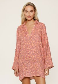 Leopardprint jurk in roze en oranje tinten, met een kraag, lange mouwen en een ontspannen pasvorm. Gemaakt van lichte stof met een zachte textuur.