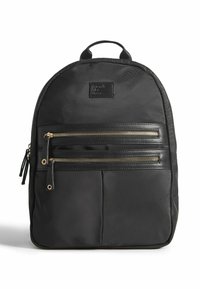 Sac à dos en nylon noir avec deux poches zippées dor�ées, une poignée renforcée et une finition texturée. Il présente une forme rectangulaire avec un haut arrondi.