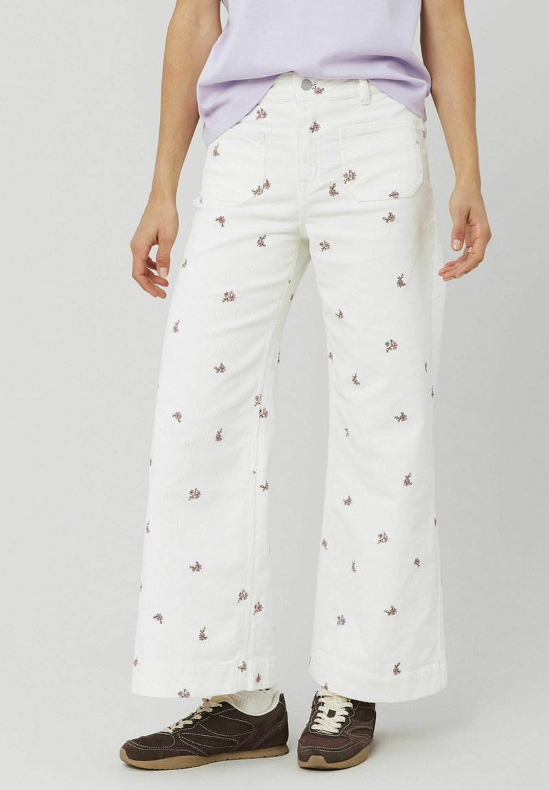 Jean large blanc avec broderie florale dans des nuances de rose. Fabriqué en coton, avec des poches avant et une fermeture à bouton classique.