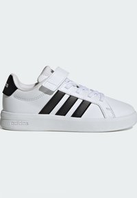 Bijele tenisice od sintetičkog materijala, s niskim rezom, crnim prugama i remenom preko vezica za dodatnu sigurnost.