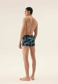 Męskie slipy w kolorze granatowym z nadrukiem liści; elastyczny pas; krótka nogawka; miękka faktura materiału; dopasowany krój.