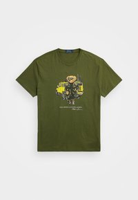 Olivgrön bomull T-shirt med en grafik av en björn i jacka bredvid ett gult fordon, med texten "Polo Bear av Ralph Lauren" nedanför.
