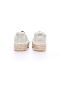 Espadrillas con un tessuto beige chiaro e strisce verdi, suole intessute in juta e design con punta arrotondata, mostrando finiture testurizzate.