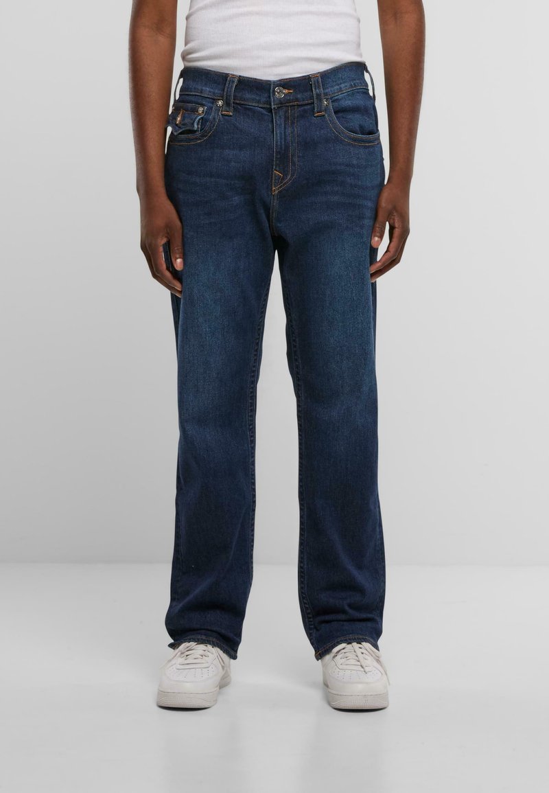 Temno modri kavbojasti jeans s ravnim krojem, petimi žepi in kontrastnim oranžnim šivom. Raztegljiv material za udobje.