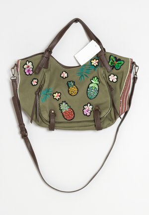 Torba oliwkowa z brązowymi paskami, ozdobiona kolorowymi, haftowanymi ananasami, kwiatami, liśćmi i motylem oraz białą metką.