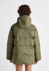 Chaqueta acolchada verde oliva con capucha, con un diseño cuadrado, patrón de acolchado horizontal y textura suave y lisa.