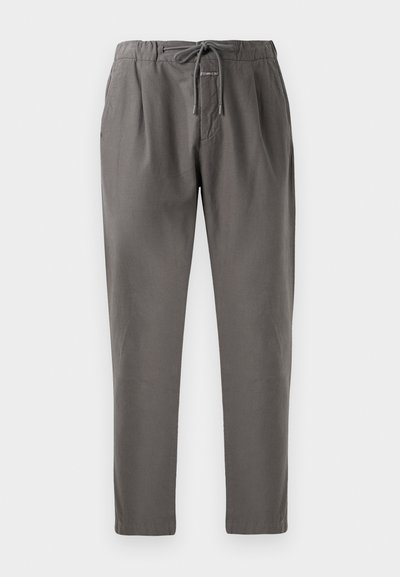 Gray cotton pants with an elastic waistband and drawstring. Features side pockets and a relaxed fit, tapering at the ankles.