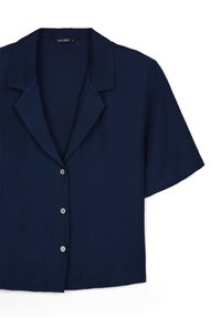 Camicetta blu navy a maniche corte realizzata in un tessuto leggero, con colletto e cinque bottoni sul davanti.