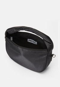 Black fabric bag with a smooth texture, curved shape, and top zipper. Features a handle and an interior tag labeled "PIECES."