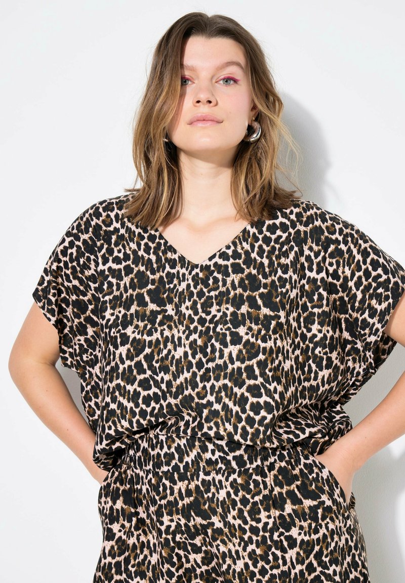 Leopard-print top med korte ærmer, V-hals, lavet af letvægtsstof. Har et kontrasterende sort og tan mønster.