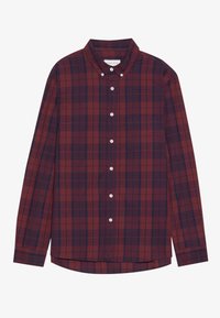 Camisa de manga larga a cuadros rojos y azul marino con cuello abotonado, bolsillo frontal y botones blancos; tela de algodón con textura suave.