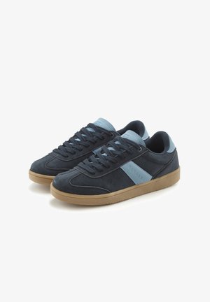 Paar dunkelgrauer Wildleder-Sneaker mit hellblauen Akzenten und Sohlen aus Kaugummirubber, nebeneinander auf weißem Hintergrund platziert.