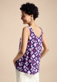 Top senza maniche multicolore con un motivo viola e rosa su un tessuto leggero. Orlo arrotondato e vestibilità rilassata.