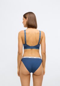 Soutien-gorge en coton bleu et culottes assorties avec des détails de logo sur les bretelles et la taille. Design simple et ajusté avec une texture lisse.